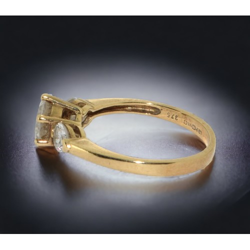 119 - A 9ct Gold and Cubic Zirconia Ring. Round cut central set accented by two heart shape stones.
Size N