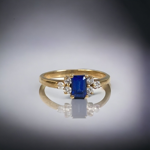 161 - A 9CT GOLD, DIAMOND & BLUE SAPPHIRE LADIES RING. 
A CENTRAL EMERALD CUT SAPPHIRE FLANKED BY SIX ROUN... 