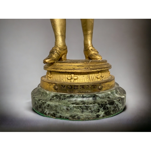 239 - A GILT BRONZE FIGURE OF A YOUNG MOZART. AFTER EMILE BRUCHON. ON MARBLE BASE. 325.CM TALL.