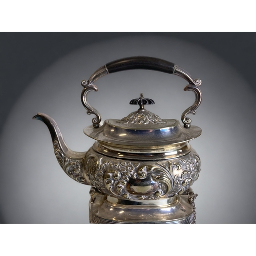 181 - A VICTORIAN SILVER PLATE SPIRIT KETTLE. RELIEF DECORATED STYLISED FOLIATE DESIGN. ON HINGES.