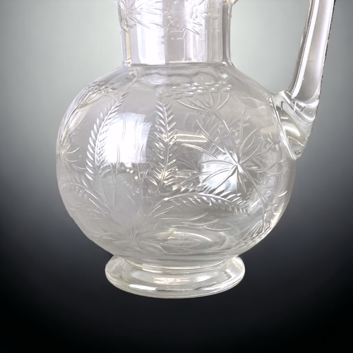 102 - A VICTORIAN CHRISTOPHER DRESSER DESIGN GLASS JUG. ENGRAVED IN STYLISED FOLIATE DESIGNS. 
13CM TALL