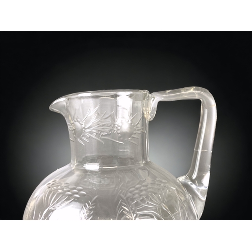 102 - A VICTORIAN CHRISTOPHER DRESSER DESIGN GLASS JUG. ENGRAVED IN STYLISED FOLIATE DESIGNS. 
13CM TALL