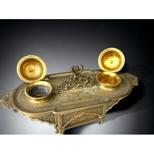 205 - A GILT BRONZE DESK STAND INKWELL.  
19TH CENTURY.
INTRICATELY DETAILED 'PERSIAN' TYPE DESIGN, DEPICT... 