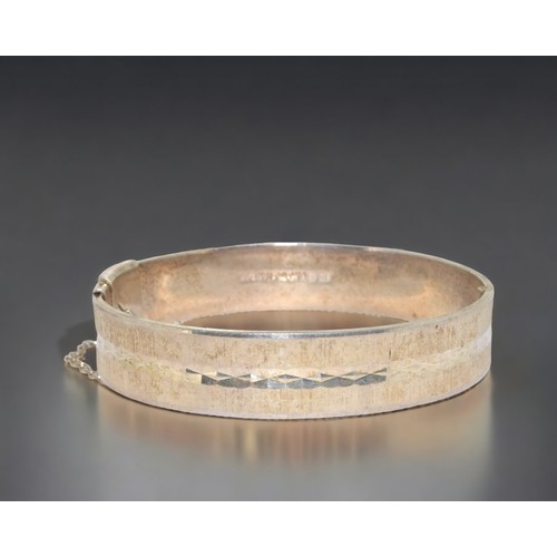 200 - A 925 silver heavy gauge solid bangle with fitted safety chain.