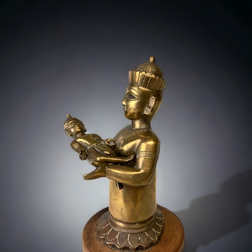 12 - A 19TH CENTURY SOUTH ASIAN BRONZE DEITY DEITY HOLDING A (DETACHABLE) BABY ALOFT. MOUNTED ON RAISED W... 