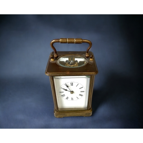 275A - A LATE VICTORIAN BRASS CARRIAGE CLOCK. FIVE BEVEL EDGED GLASS PANELS. WHITE ENAMEL DIAL WITH BLACK R... 