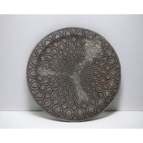 303 - A LARGE PERSIAN BRONZE TRAY. EMBOSSED FOLIATE DESIGN. 
DIAMETER - 60CM