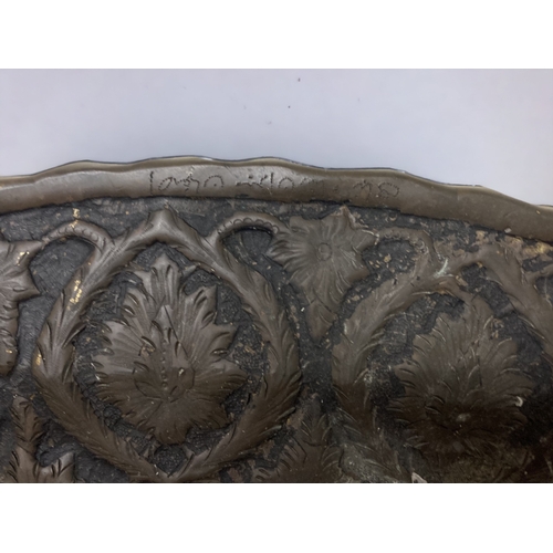 303 - A LARGE PERSIAN BRONZE TRAY. EMBOSSED FOLIATE DESIGN. 
DIAMETER - 60CM