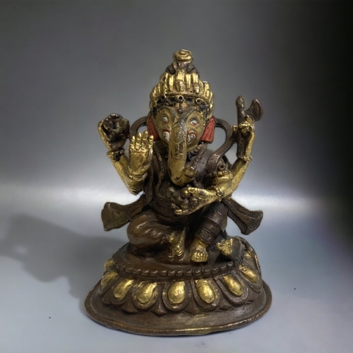 306 - AN INDIAN PATINATED & GILT BRONZE FIGURE OF GANESH. 
HEIGHT - 10CM