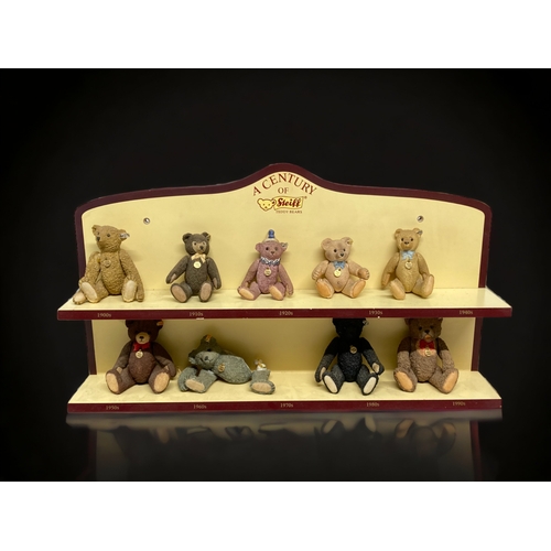 525 - A COLLECTION OF NINE 'A CENTURY OF STEIFF' PORCELAIN TEDDY BEARS. WITH COLLECTORS DISPLAY SHELF.