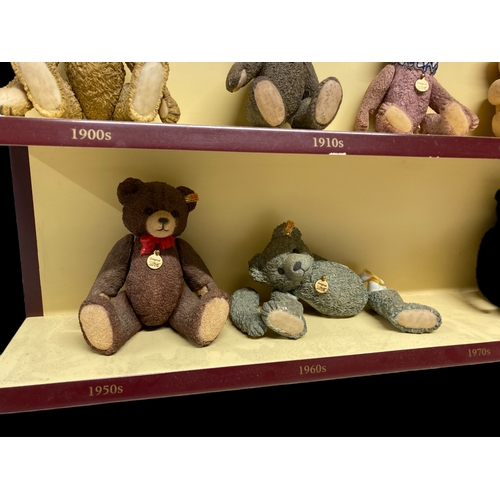 525 - A COLLECTION OF NINE 'A CENTURY OF STEIFF' PORCELAIN TEDDY BEARS. WITH COLLECTORS DISPLAY SHELF.