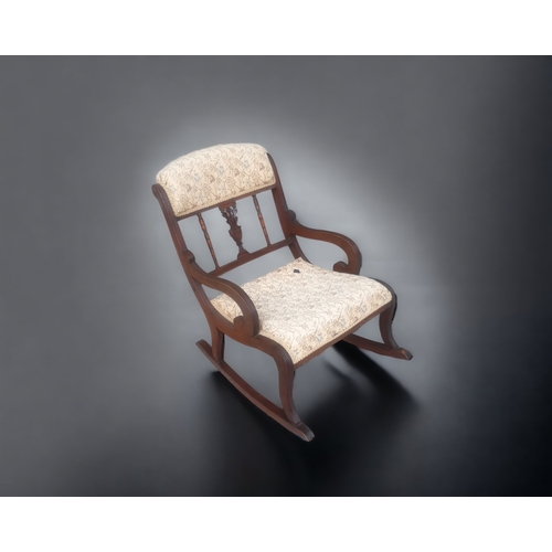 27 - A VICTORIAN CARVED & UPHOLSTERED ROCKING CHAIR.