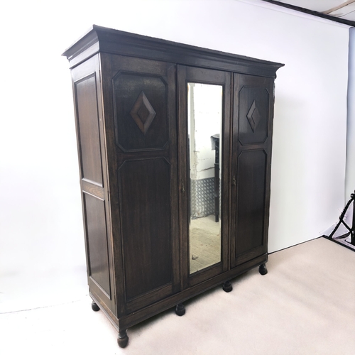36 - CARVED DARK OAK TRIPLE WARDROBE. WITH DRAWERS AND SHOE RACK.