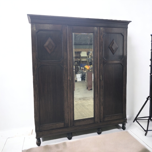 14 - CARVED DARK OAK TRIPLE WARDROBE. WITH DRAWERS AND SHOE RACK.