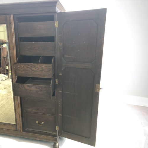 14 - CARVED DARK OAK TRIPLE WARDROBE. WITH DRAWERS AND SHOE RACK.