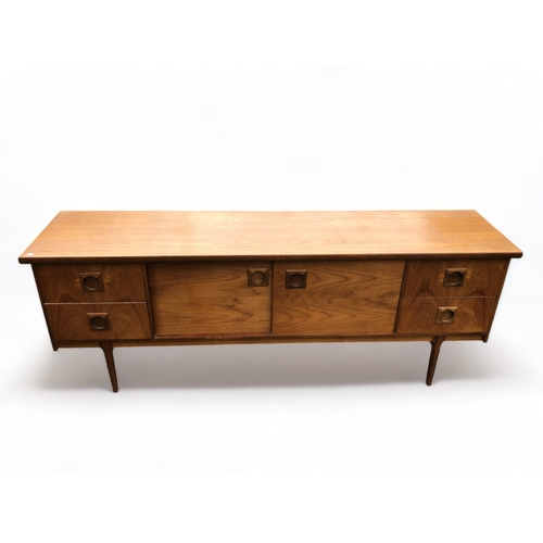 48 - A MID-CENTURY TEAK SIDEBOARD. CENTRAL SLIDING DOORS FLANKED BY PAIRS OF DRAWERS.