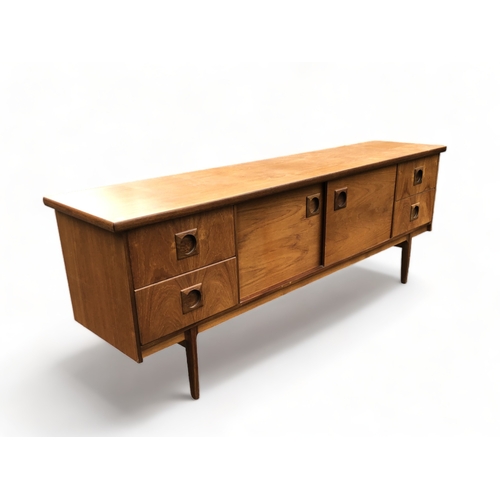 48 - A MID-CENTURY TEAK SIDEBOARD. CENTRAL SLIDING DOORS FLANKED BY PAIRS OF DRAWERS.