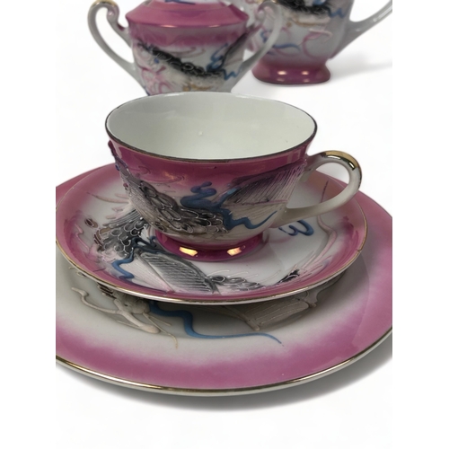 279 - A VINTAGE JAPANESE GEISHA LITHOPHANE TEASET. PINK GROUND WITH RELIEF DECORATED DRAGONS.