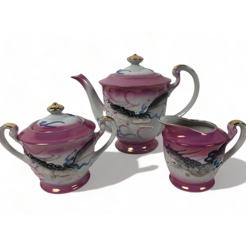 279 - A VINTAGE JAPANESE GEISHA LITHOPHANE TEASET. PINK GROUND WITH RELIEF DECORATED DRAGONS.