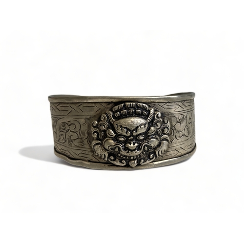 269 - A vintage Tibetan engraved cuff bracelet, together with one other.