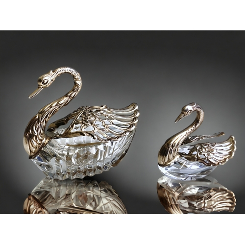 595 - Two sterling Silver & cut glass Swan salts. Together with a silver salt spoon.