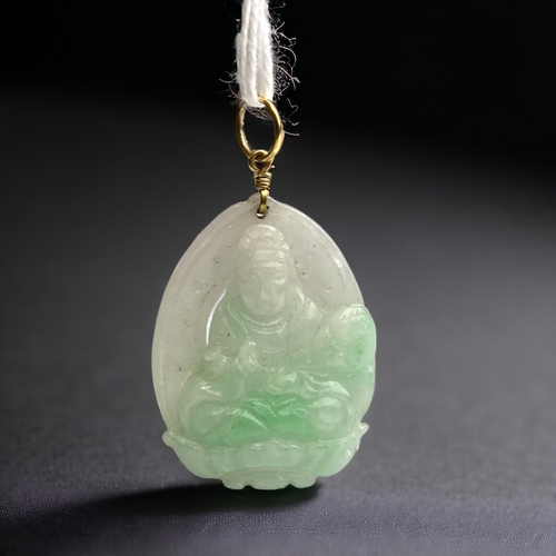 632 - A Chinese yellow metal mounted carved jade pendant. 
Depicting seated Guanyin.
45 x 25mm