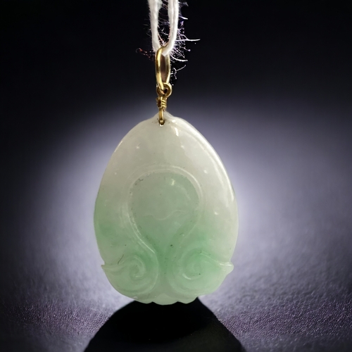 632 - A Chinese yellow metal mounted carved jade pendant. 
Depicting seated Guanyin.
45 x 25mm