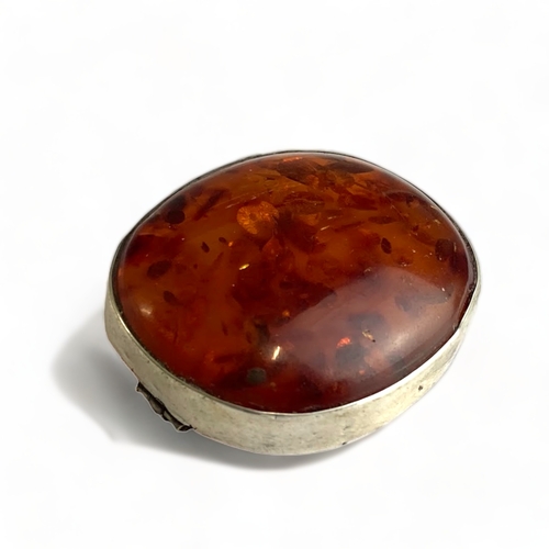 501 - A Silver and Baltic amber oval brooch, 4.1cm by 3.7cm. Unmarked but tested.