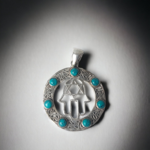 679 - A SILVER FILIGREE 'HAND OF MIRIAM' PENDANT. SET WITH TURQUOISE.
DIAMETER - 40MM