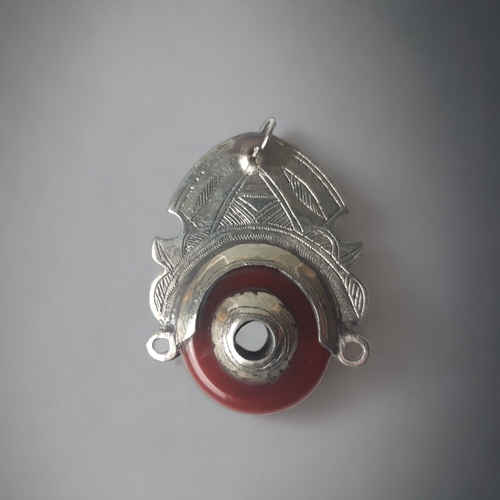 680 - AFRICAN TRIBAL SILVER TUAREG PENDANT. SET WITH A POLISHED RED AGATE. ENGRAVED DESIGN.
55 X 40MM