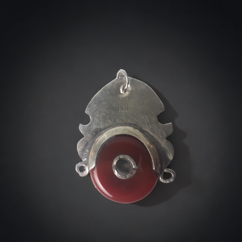 680 - AFRICAN TRIBAL SILVER TUAREG PENDANT. SET WITH A POLISHED RED AGATE. ENGRAVED DESIGN.
55 X 40MM