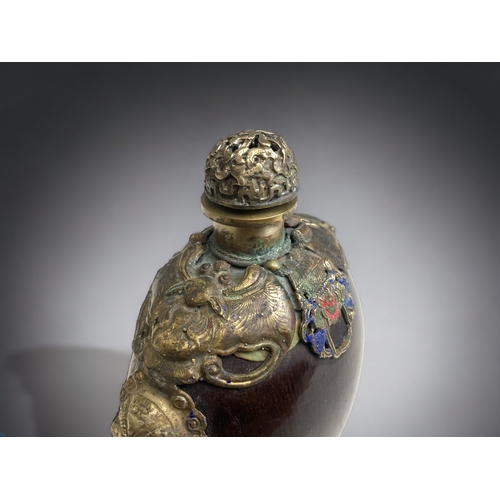 69 - A Chinese polished Nut, metal mounted large snuff bottle. 
Marks to base.
Height - 11.5 cm