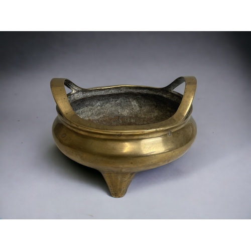 70 - A large Chinese polished bronze twin handle censer. 
Qing dynasty.  Raised on three tapered feet.
Re... 