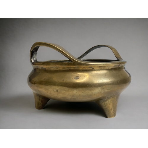 70 - A large Chinese polished bronze twin handle censer. 
Qing dynasty.  Raised on three tapered feet.
Re... 