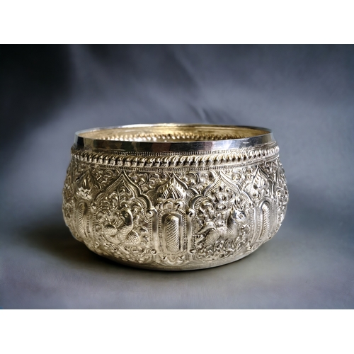 765 - A Burmese Silver 'Thabeik' bowl.
Ornately embellished with chased repoussé series of animals. Inscri... 