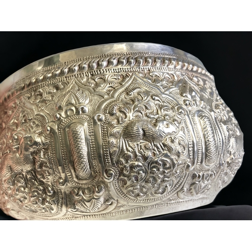 765 - A Burmese Silver 'Thabeik' bowl.
Ornately embellished with chased repoussé series of animals. Inscri... 