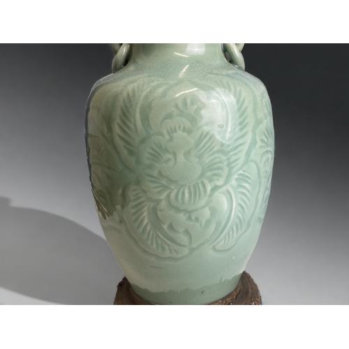 97 - A CHINESE LONGQUAN PORCELAIN TABLE LAMP. ENGRAVED FOLIATE DESIGN, WITH WHITE JADE FINIAL. 
HEIGHT - ... 