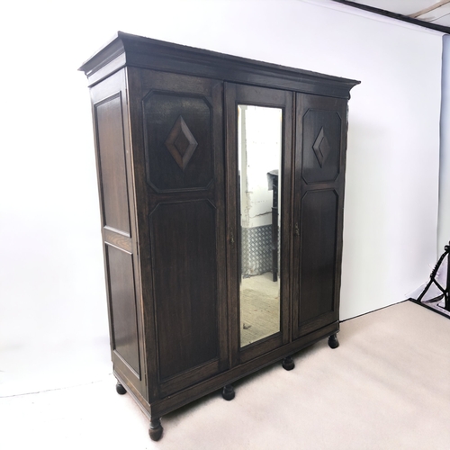 112 - CARVED DARK OAK TRIPLE WARDROBE. WITH DRAWERS AND SHOE RACK.