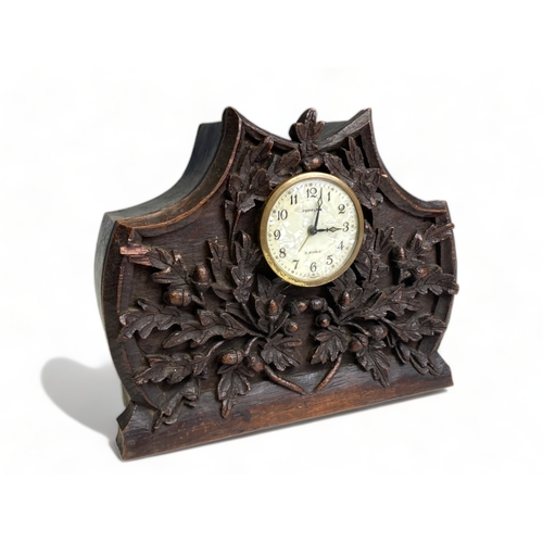 244 - A 19TH CENTURY CARVED OAK BLACK FOREST MANTEL CLOCK. CARVED ACORNS & LEAVES. 
18 X 21CM