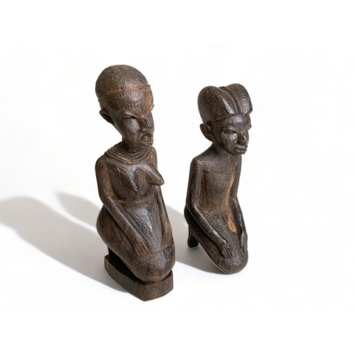 358 - 3 East African carved female seated figures, together with another.