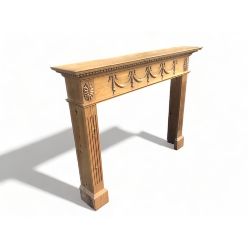 366 - A CARVED PINE FIRE SURROUND.