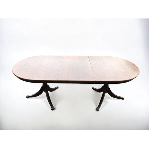 368 - A MAHOGANY EXTENDING TRIPOD DINING TABLE. CENTRAL LEAF. METAL LION PAW CASTERS.