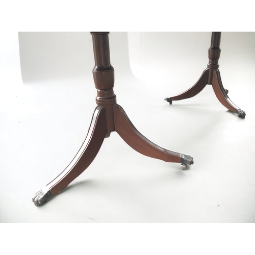 368 - A MAHOGANY EXTENDING TRIPOD DINING TABLE. CENTRAL LEAF. METAL LION PAW CASTERS.