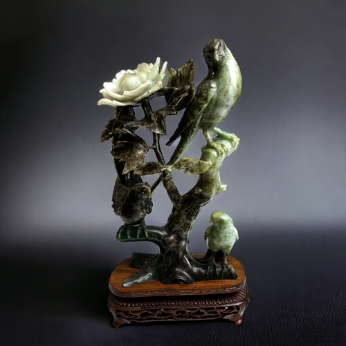 174 - A collection of Chinese carved jade & hardstone sculptures. Including a bird & flower group on carve... 