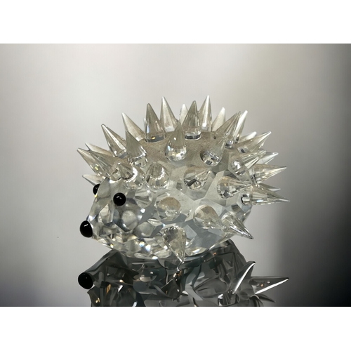 140 - A BOXED SWAROVSKI CRYSTAL HEDHOG.
Together with a hand made clear glass fish.