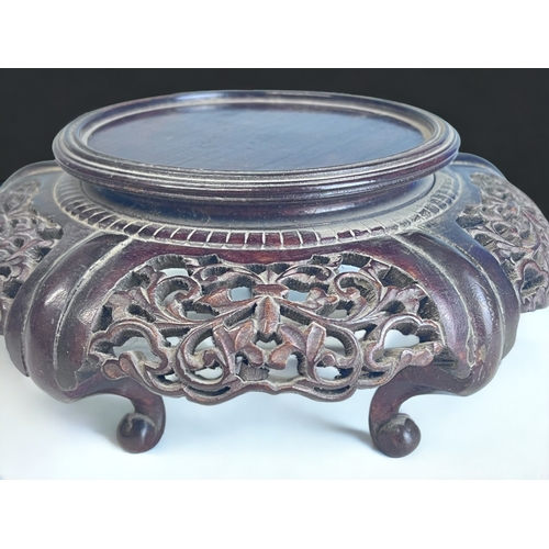 177 - A CHINESE CARVED WOOD STAND.
Raised on four curved feet. With stylised foliate design.