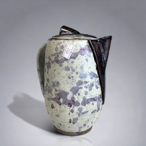 130 - AN UNUSUAL STUDIO POTTERY JUG & COVER. 
With applied & painted spout & knop. 
Unmarked.
Height - 20c... 