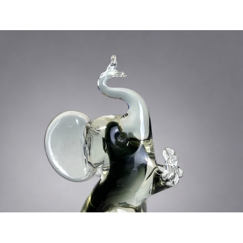 171 - A VINTAGE MURANO GLASS ELEPHANT FIGURE. 
By Campanella, in smokey grey, sat on his haunches in a beg... 