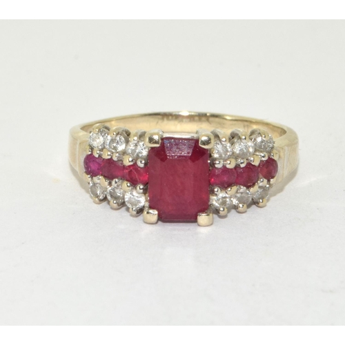 434 - 14ct gold ladies Diamond and Ruby ring set with a emerald cut Ruby centre stone size P