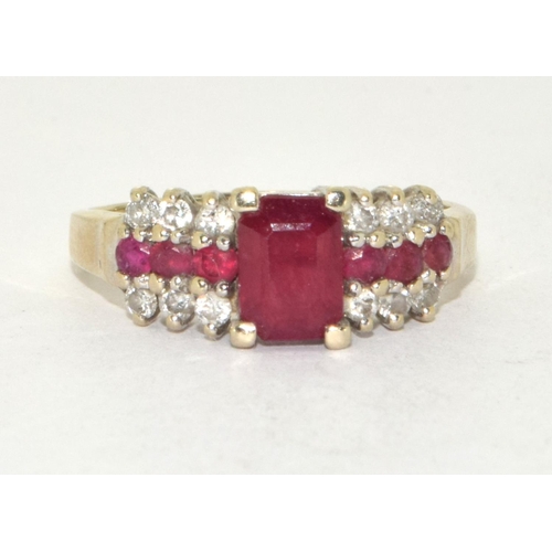 434 - 14ct gold ladies Diamond and Ruby ring set with a emerald cut Ruby centre stone size P